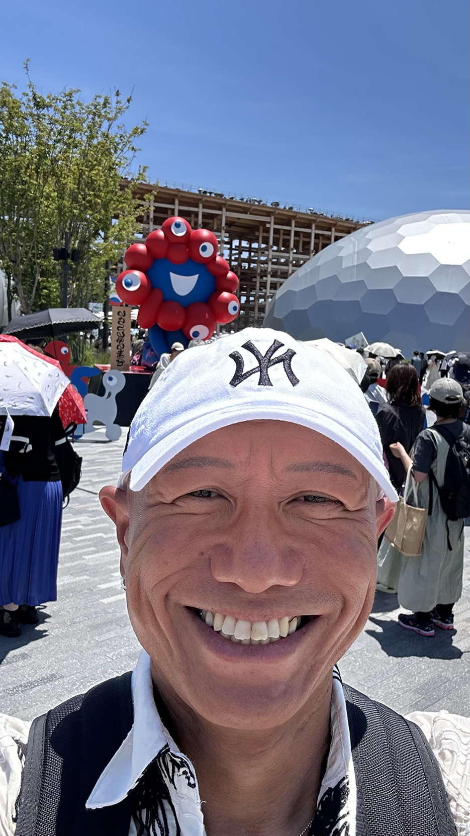 万博会場にてミャクミャクと一緒に写っている会長さんのお写真